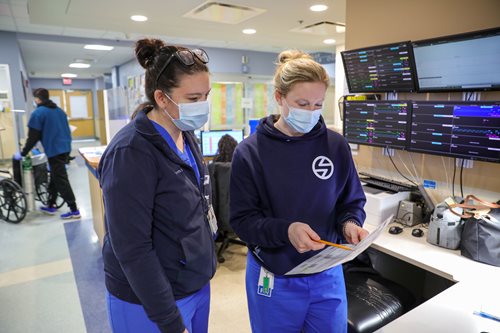 Capt. Samantha DiBlasi, left, a registered nurse working with the Air Force medical team at Lawrence General Hospital, discusses the team’s schedule with Kate Maguire, an Emergency Center charge nurse. (U.S. Army photo by Spc. Daniel Thompson)